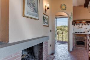 a living room with a fireplace and a kitchen at Il Pintello - Il Riccio in Massanera