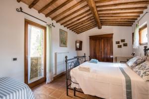 un dormitorio con una cama y una ventana en La Farneta, en Monteriggioni 18 fotos más