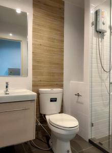 Un baño con inodoro, lavabo y ducha. en อพาร์ตเม้นต์แสนสงบ, en Thonhuri