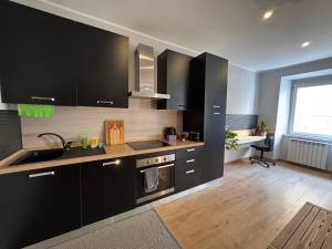 a kitchen with black cabinets and a sink and a window at La Dea Bendata in Rocca Priora