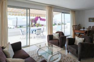 un soggiorno con divani e un tavolo di vetro di Strandnahes Haus Mit Terrasse Zum Sonnenuntergang a Los Realejos