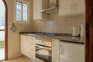 una cucina con mobili bianchi e un lavandino di Strandnahes Haus Mit Terrasse Zum Sonnenuntergang a Los Realejos Altre 29 foto
