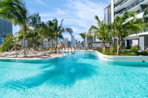 a large swimming pool with palm trees and buildings at Luxury 2-Bdrm Condo in the Heart of Downtown Miami in Miami