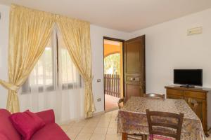 een woonkamer met een tafel en een rode bank bij Il Girasole - Malva in Venturina Terme