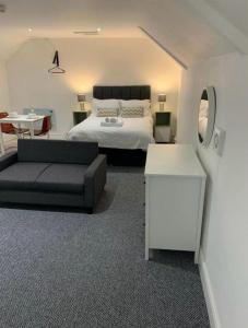 Un dormitorio con una cama, un sofá y una mesa. en Flat 6 - Eign St Hereford, en Hereford