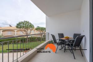 un balcon avec une table et des chaises et une maison dans l'établissement #284 Vista das Ondas by Home Holidays, à Olhos de Água