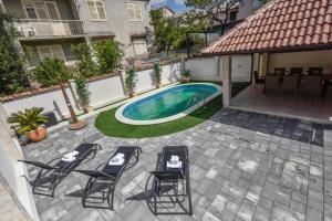 a patio with chairs and a swimming pool at Villa Karla in Novalja +17 photos