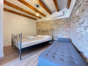 a bedroom with a bed and a stone wall at Villa Karla in Novalja