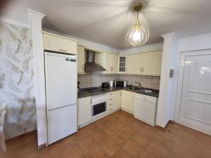 eine Küche mit weißen Geräten und einer Decke in der Unterkunft El Rincon 2 in Los Cristianos