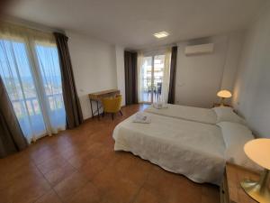 ein Schlafzimmer mit einem großen weißen Bett und großen Fenstern in der Unterkunft El Rincon 2 in Los Cristianos + 21 Fotos