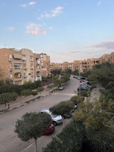 a street with cars parked in a parking lot at Beverly Hills apartment in Sheikh Zayed