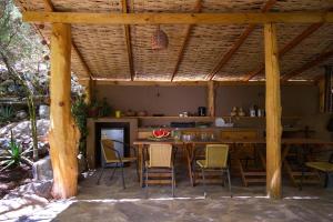 a dining area with a table and chairs under a pavilion at Cabañas El Albaricoque Cochiguaz in El Sanjeado