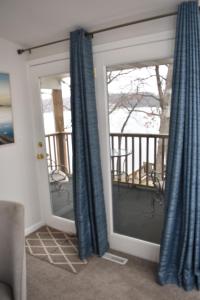 una camera con due finestre con tende blu di Lakefront Home with Amazing Views, Hot tub, Boat JetSki Rental Option a Lake Ozark
