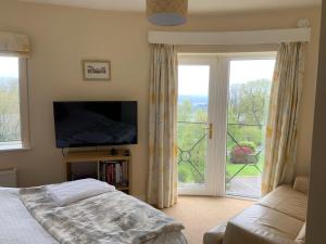a bedroom with a bed and a tv and a window at Mariasplace in Cork