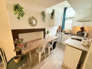 eine Küche mit einem großen Holztisch in einem Zimmer in der Unterkunft Cosy Azur - T1 - Place Verdun in Pau