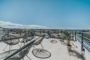 a patio with chairs and tables on a balcony at Haus In Novigrad Mit Privatem Pool in Karpinjan