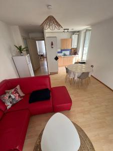 a living room with a red couch and a table at Les Platanes - Michel Ange in Lamalou-les-Bains