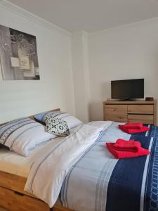 una camera da letto con un letto con asciugamani rossi di Zentrale, Liebevoll Eingerichtete Ferienwohnung a Monheim