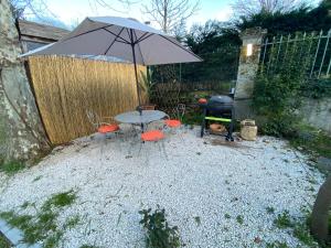 a table and chairs with an umbrella and a grill at Les Platanes - Michel Ange in Lamalou-les-Bains +2 photos