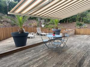 a patio with a table and chairs on a wooden deck at Anglet Chiberta - Proche plage et golf in Anglet