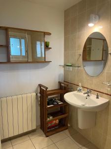 a bathroom with a sink and a mirror at Anglet Chiberta - Proche plage et golf in Anglet +11 photos