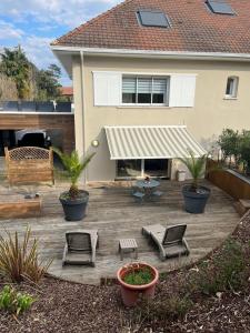 a patio with chairs and awning in front of a house at Anglet Chiberta - Proche plage et golf in Anglet