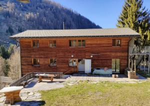 a wooden house with a patio and a mountain at Gasthaus Heiligkreuz in Binn
