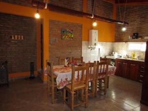 a dining room with a table and chairs in a kitchen at CABAÑAS SANTA RITA - Tanti, Córdoba in Tanti