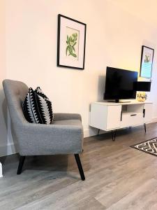 a living room with a chair and a tv at Luxury Flat in Birmingham City West Midlands in Birmingham