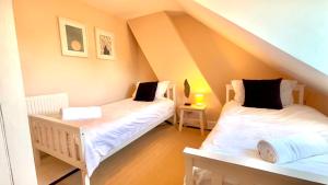 a bedroom with two beds in a attic at Seascape Luxury Cottage Southwold - Free Parking in Reydon