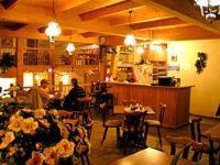 a restaurant with people sitting at tables in a room at Hotel-Pension Märkischheide in Vetschau