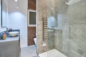 a bathroom with a shower and a toilet and a sink at Modern Two Bedroom Apartment in Valletta in Valletta +34 photos