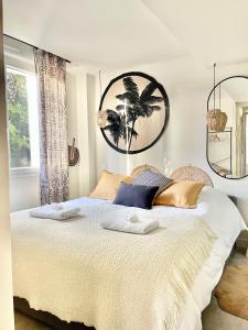 a bedroom with a large bed with two towels on it at Bas de villa la sablhyeres- 300m Plage de la Capte - 2 hébergements disponibles in Hyères