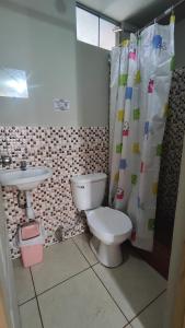 a bathroom with a toilet and a sink at Huachuma Rooms in Huaraz