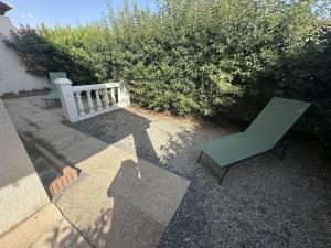 two green chairs and a bench on a patio at G1 Manadiers T3 parking piscine terrasse in Saintes-Maries-de-la-Mer