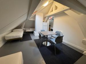 una habitación con una mesa y sillas y un sofá en Charming 3P en attique Genève Veyrier Salève, en Veyrier