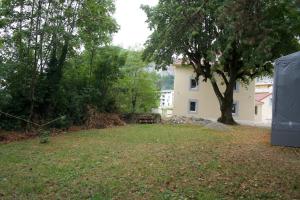 un patio con una casa blanca y un árbol en Charming 3P en attique Genève Veyrier Salève, en Veyrier