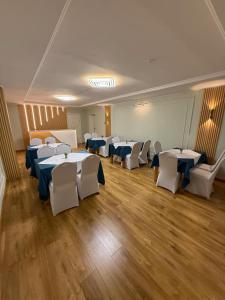 a room with tables and white chairs in a room at Diplomat Noble Hotel in Ulaanbaatar +18 photos