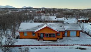 an orange house with snow on the roof at Lovely house in Abisko in Abisko