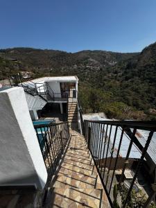 a stairway leading up to a building with mountains in the background at Terrazas Hotel and Hostel in Taxco de Alarcón