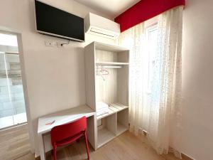 una stanza con una scrivania e una TV a parete di Vacation Venice Rooms a Mestre