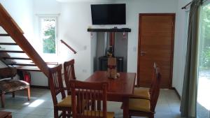 a dining room with a table and a television at Los ciruelos mar de cobo in Mar de Cobo