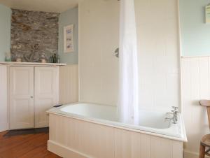 a white bath tub in a bathroom with a window at School House in Aberffraw +41 photos