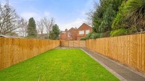a backyard with a wooden fence and a yard at Santi House in Boston