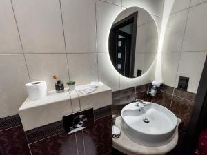 a bathroom with a sink and a mirror at Apartments On Zaliznychna 49 in Ivano-Frankivsʼk +78 photos