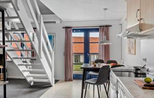a kitchen with stairs leading to a dining room at Cozy Apartment In Gudhjem With Sauna in Gudhjem +9 photos