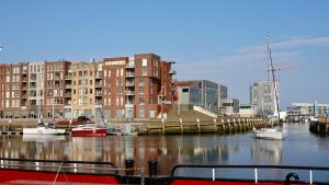 een groep boten aangemeerd in een jachthaven met gebouwen bij BizStay Harbour III Scheveningen Apartments in Scheveningen