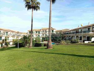 a park with palm trees in front of a building at Moradia Townhouse S Sebastião F in Guia