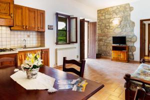 a kitchen and dining room with a table with flowers on it at Capracotta - Luna in Montemassi