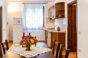 a kitchen with a table with a vase of flowers on it at Capracotta - Aurora in Montemassi